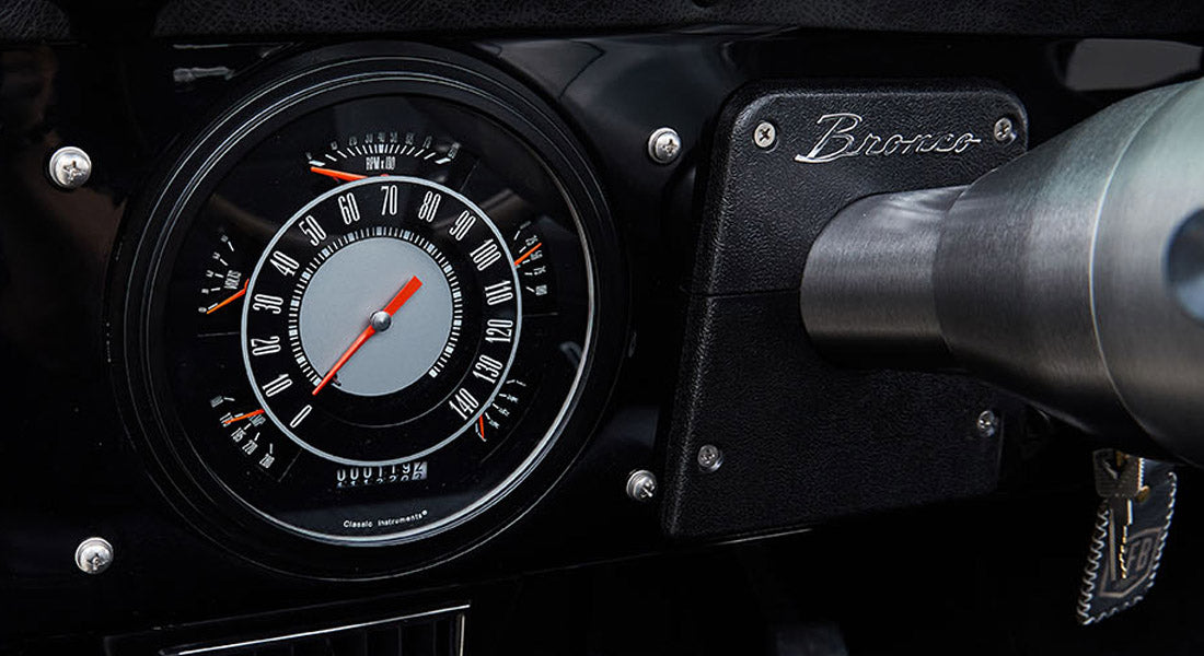 Speedometer and ignition key in Classic Ford Bronco dashboard with black background and red needle