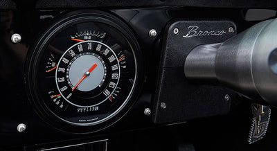 Speedometer and ignition key in Classic Ford Bronco dashboard with black background and red needle
