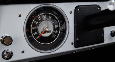 Classic Ford Bronco dashboard speedometer with fuel and temperature gauges and white background