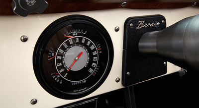 Speedometer gauge on the dashboard of a Classic Ford Bronco with Bronco emblem plate