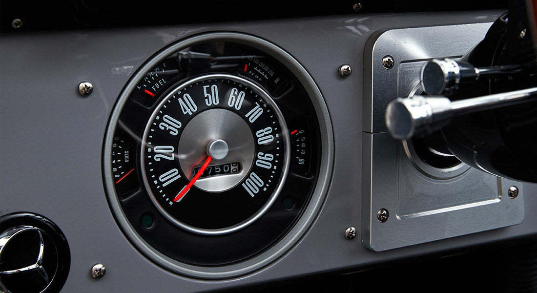 Classic Ford Bronco speedometer and fuel, volts gauges on silver dashboard panel with steering shaft