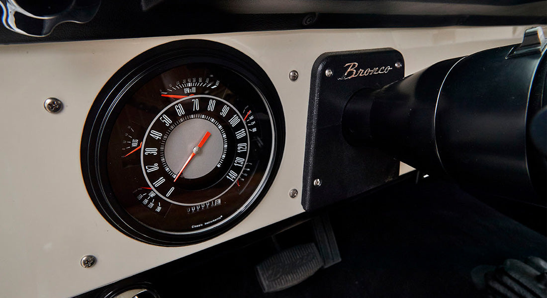Dashboard speedometer with 'Bronco' plaque on steering column of Classic Ford Bronco