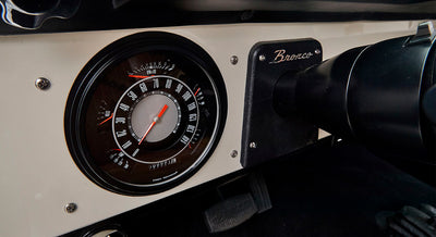 Dashboard speedometer with 'Bronco' plaque on steering column of Classic Ford Bronco