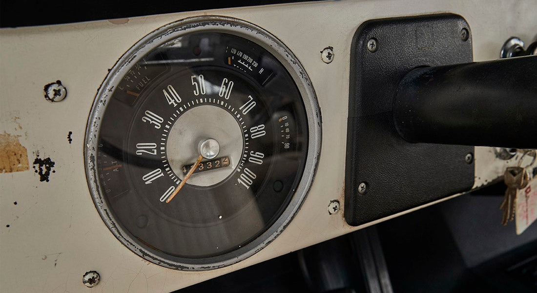 Worn Classic Ford Bronco speedometer with black dashboard panel showing mileage