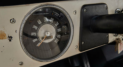 Worn Classic Ford Bronco speedometer with black dashboard panel showing mileage