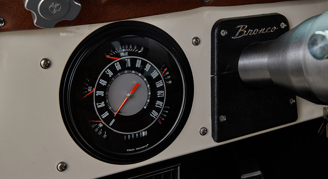Classic Ford Bronco dashboard with speedometer, RPM gauge, and Bronco label on panel