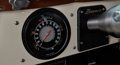 Classic Ford Bronco dashboard with speedometer, RPM gauge, and Bronco label on panel