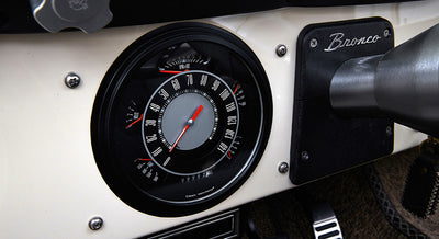 Classic Ford Bronco speedometer showing detailed instrument cluster on beige dashboard