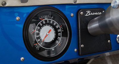 Classic Ford Bronco black circular speedometer with 'Bronco' script on dashboard