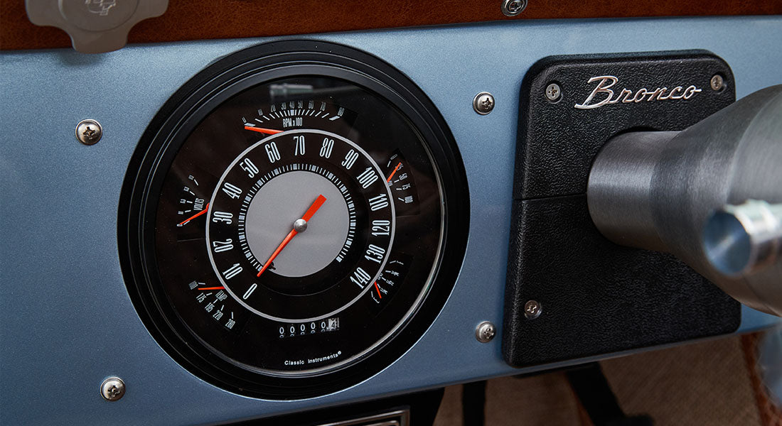 Classic Ford Bronco speedometer and rpm gauge on blue dashboard with Bronco emblem