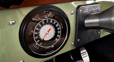Speedometer gauge with Bronco emblem on light green dashboard of Classic Ford Bronco
