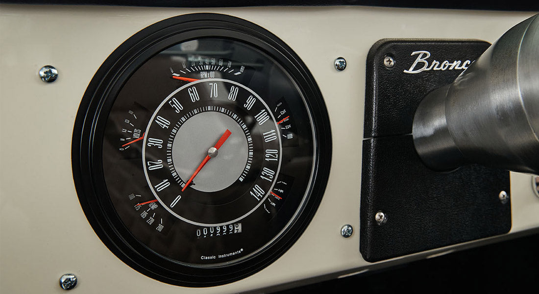 Classic Ford Bronco speedometer and tachometer on a beige dashboard