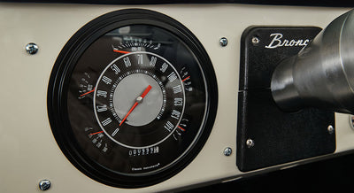 Classic Ford Bronco speedometer and tachometer on a beige dashboard