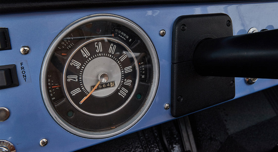 Close-up of speedometer and dashboard controls in a blue Classic Ford Bronco