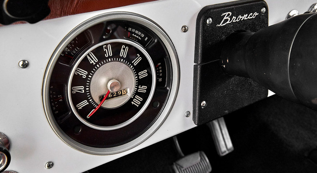 Close-up of Classic Ford Bronco speedometer and instrument gauge cluster on white dashboard