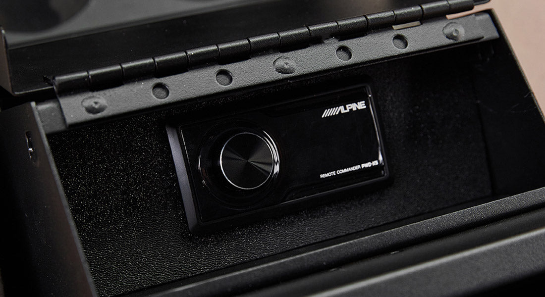 Alpine remote commander stereo control mounted inside Classic Ford Bronco dashboard compartment