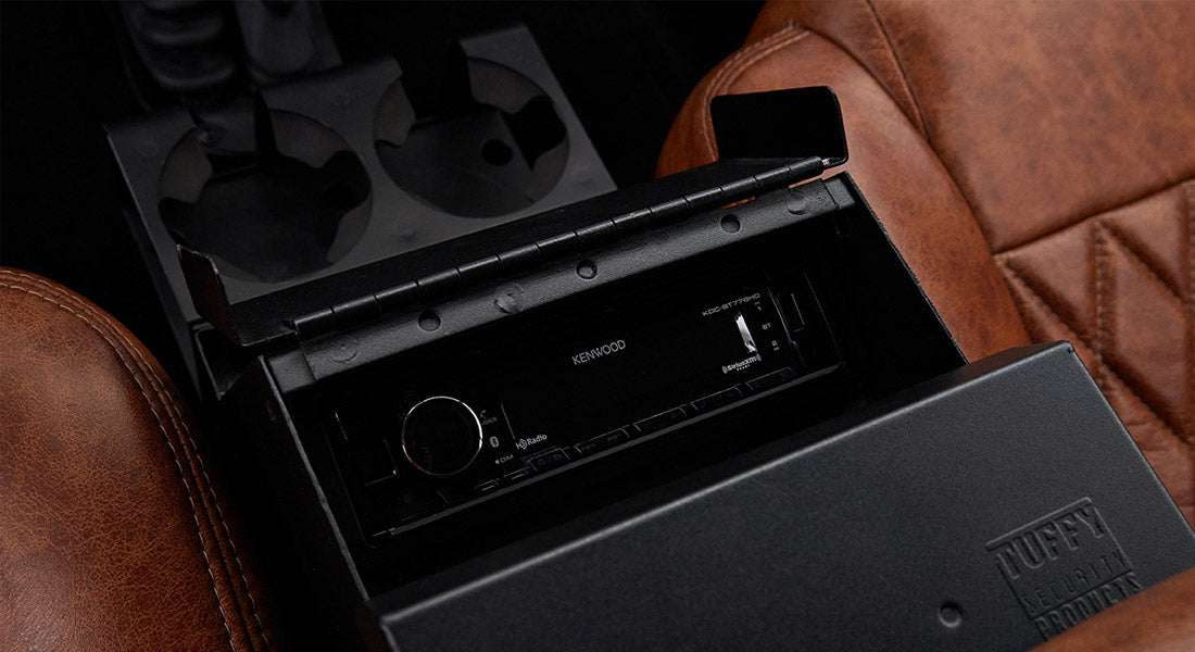 Kenwood stereo system installed in black storage console with cup holders