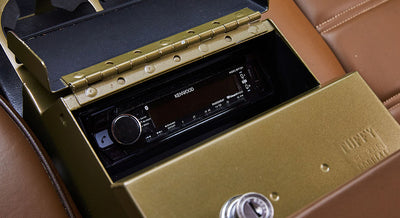 Kenwood stereo unit inside a green metal enclosure in Classic Ford Bronco interior