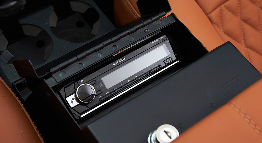 Kenwood stereo system installed in the center console of a Classic Ford Bronco with tan quilted seats.
