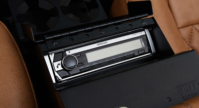 Kenwood stereo system installed in center console of Classic Ford Bronco with tan leather seats.