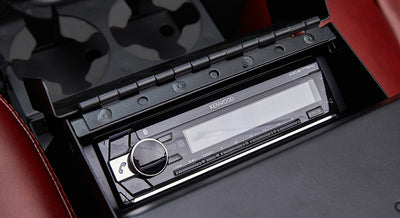 Kenwood stereo unit installed in a black compartment with red leather seats visible
