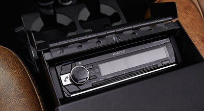Kenwood stereo console inside Classic Ford Bronco with brown seat next to it