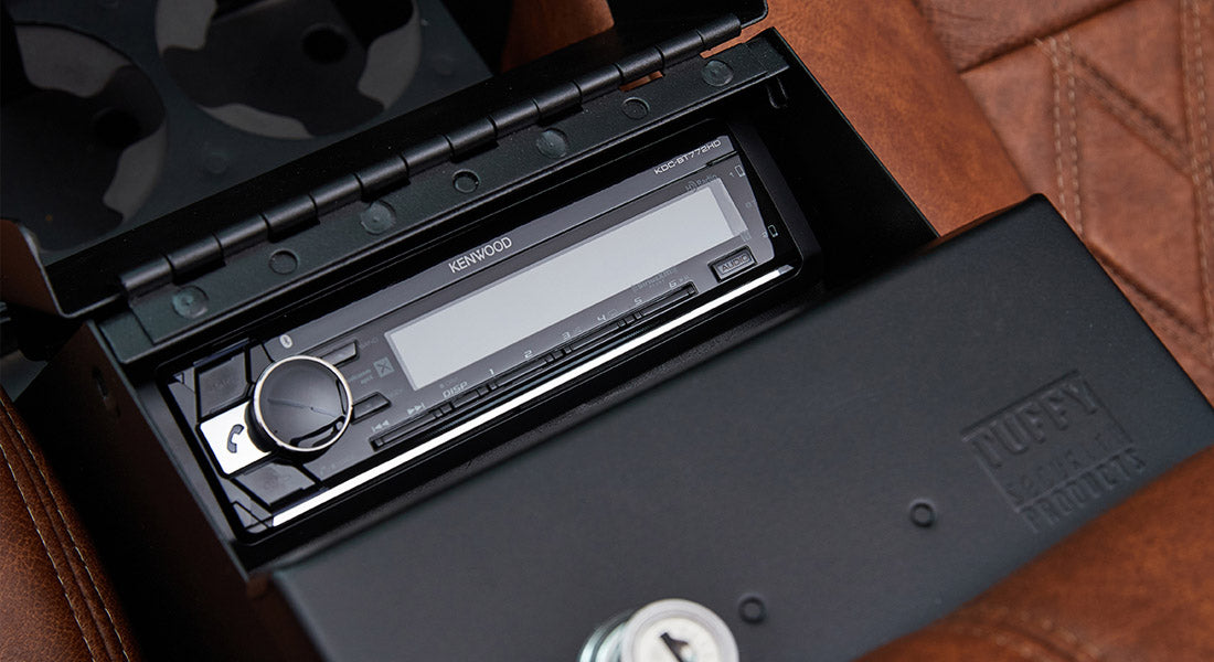 Kenwood stereo console installed with a locked black Tuffy security box nearby