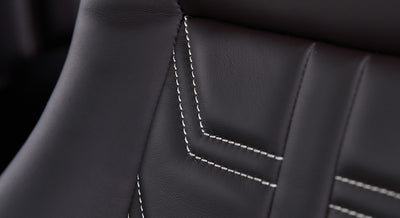 Close-up of black leather seat stitching inside a Classic Ford Bronco