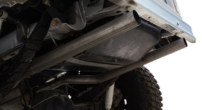 Undercarriage view showing exhaust straight pipes and rear tire of a Classic Ford Bronco