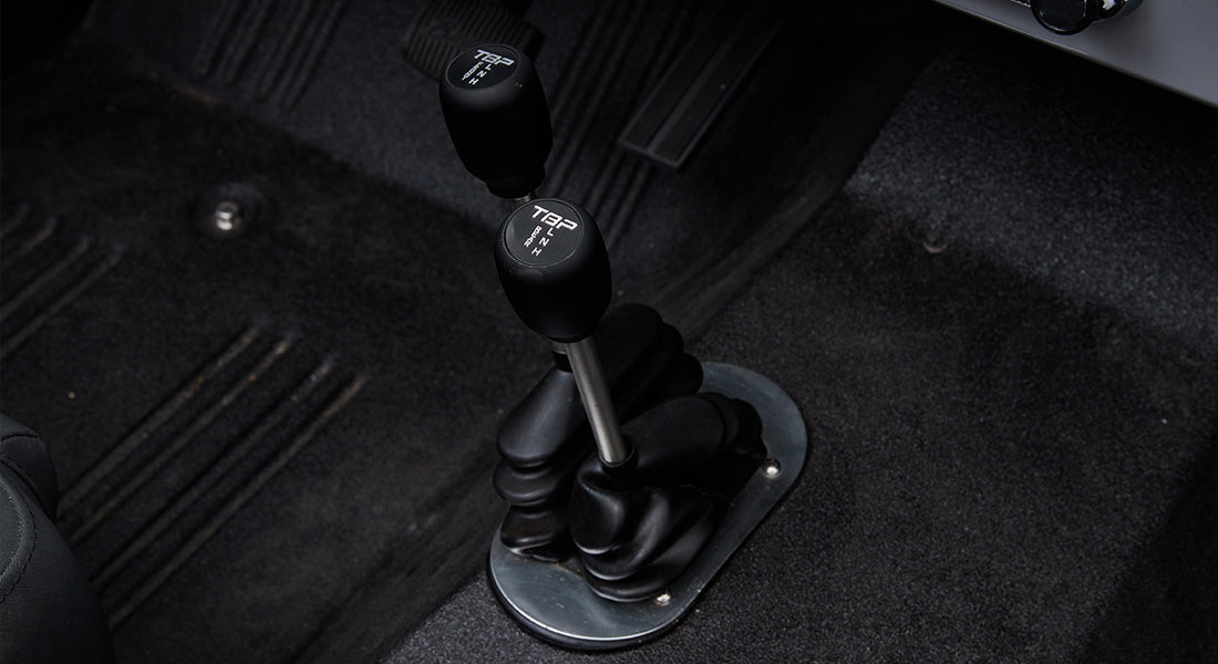 Black transfer case shifters on a Classic Ford Bronco with carpeted floor