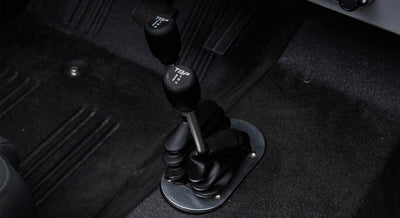 Black transfer case shifters on a Classic Ford Bronco with carpeted floor