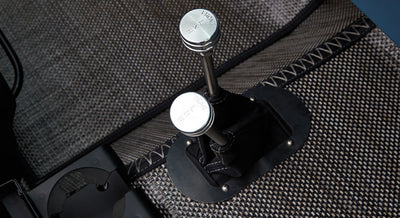 Two metal transfer case levers labeled 'FRONT' and 'REAR' next to patterned floor mat in classic Ford Bronco