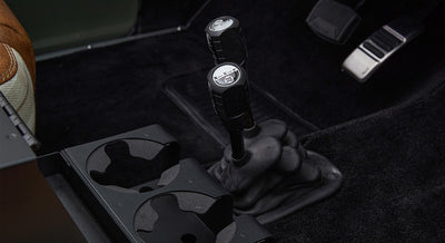 Gear shifters and cup holders shown on carpeted floor of Classic Ford Bronco interior