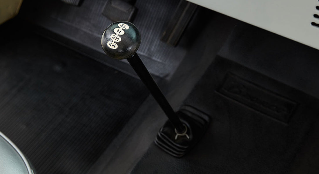 Close-up of Classic Ford Bronco transfer case lever with four-wheel drive settings on black knob.