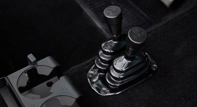 Two black gear shift levers on the floor of Classic Ford Bronco