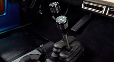 Two transfer case shifters with gear markings inside Classic Ford Bronco