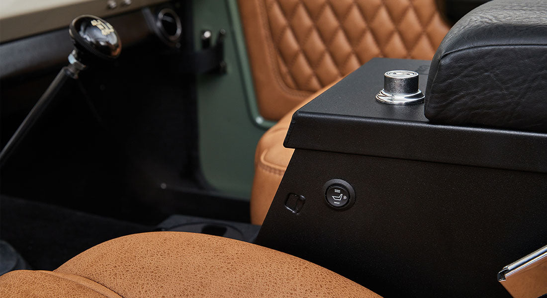 Close-up view of tan leather upholstery and black metal control lever inside a Classic Ford Bronco