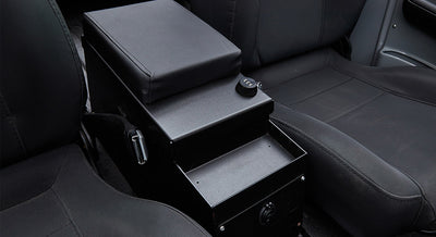 Black metal Tuffy security box between black seats inside a Classic Ford Bronco