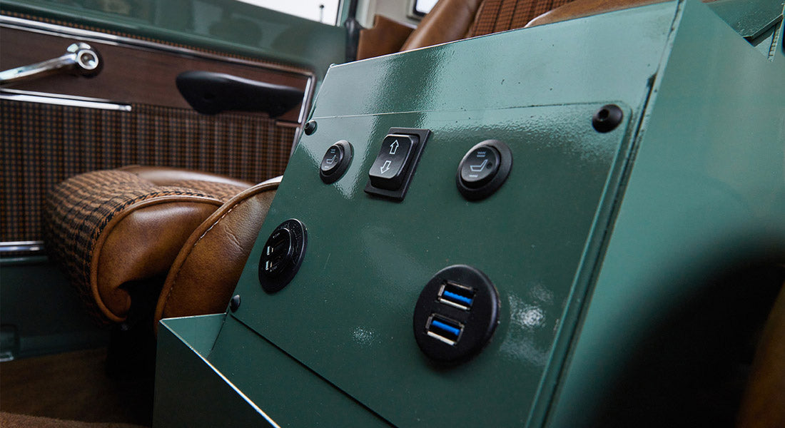 Green metal control panel with buttons and USB ports inside Classic Ford Bronco