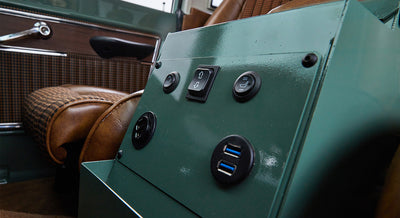 Green metal control panel with buttons and USB ports inside Classic Ford Bronco