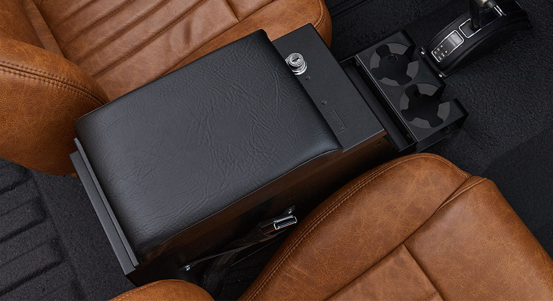 Center console and brown leather seats inside a Classic Ford Bronco featuring a black Tuffybox