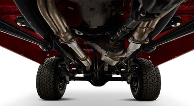 Undercarriage view of red Classic Ford Bronco showing exhaust system, rear axle, and tires