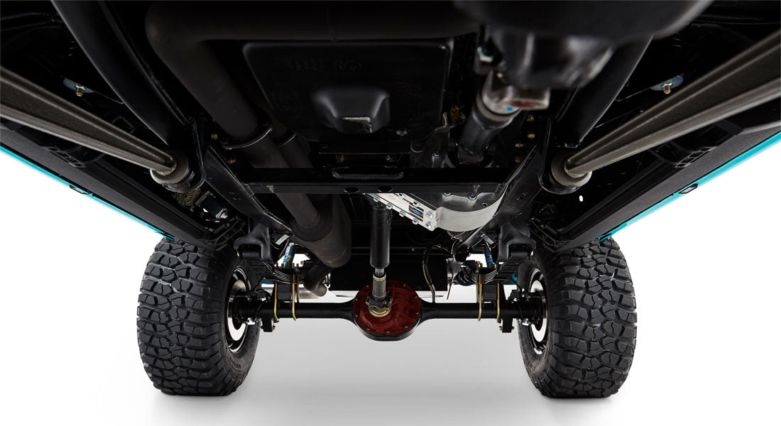 Classic Ford Bronco undercarriage showing clean suspension, black differential housing, and large off-road tires
