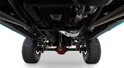 Classic Ford Bronco undercarriage showing clean suspension, black differential housing, and large off-road tires
