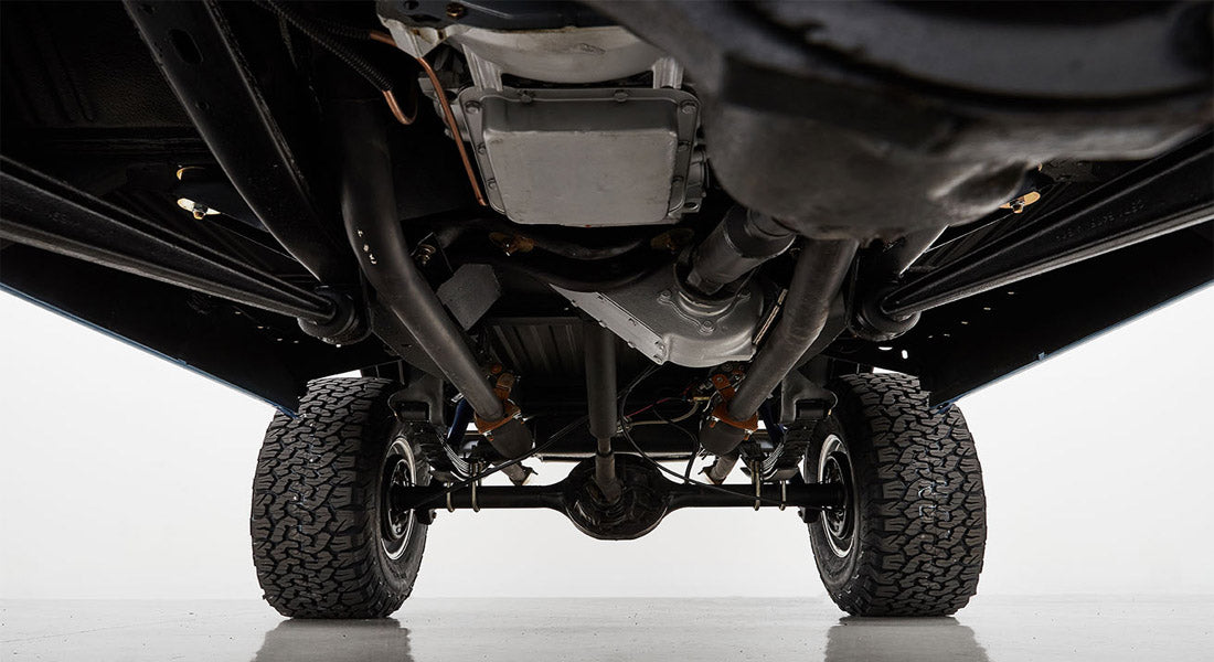 Undercarriage view showing axles, suspension, and tires of a Classic Ford Bronco