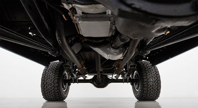 Undercarriage view showing axles, suspension, and tires of a Classic Ford Bronco