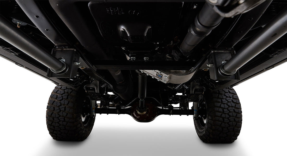 Undercarriage view showing vehicle axle, tires, and suspension components
