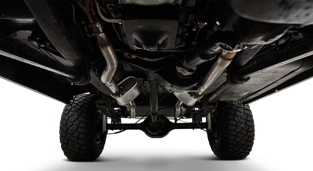 View of Classic Ford Bronco undercarriage showing frame, drive shaft, exhaust, and tires