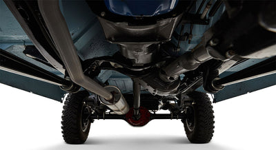 Undercarriage view showing exhaust pipe, drivetrain, and rear axle of a Classic Ford Bronco