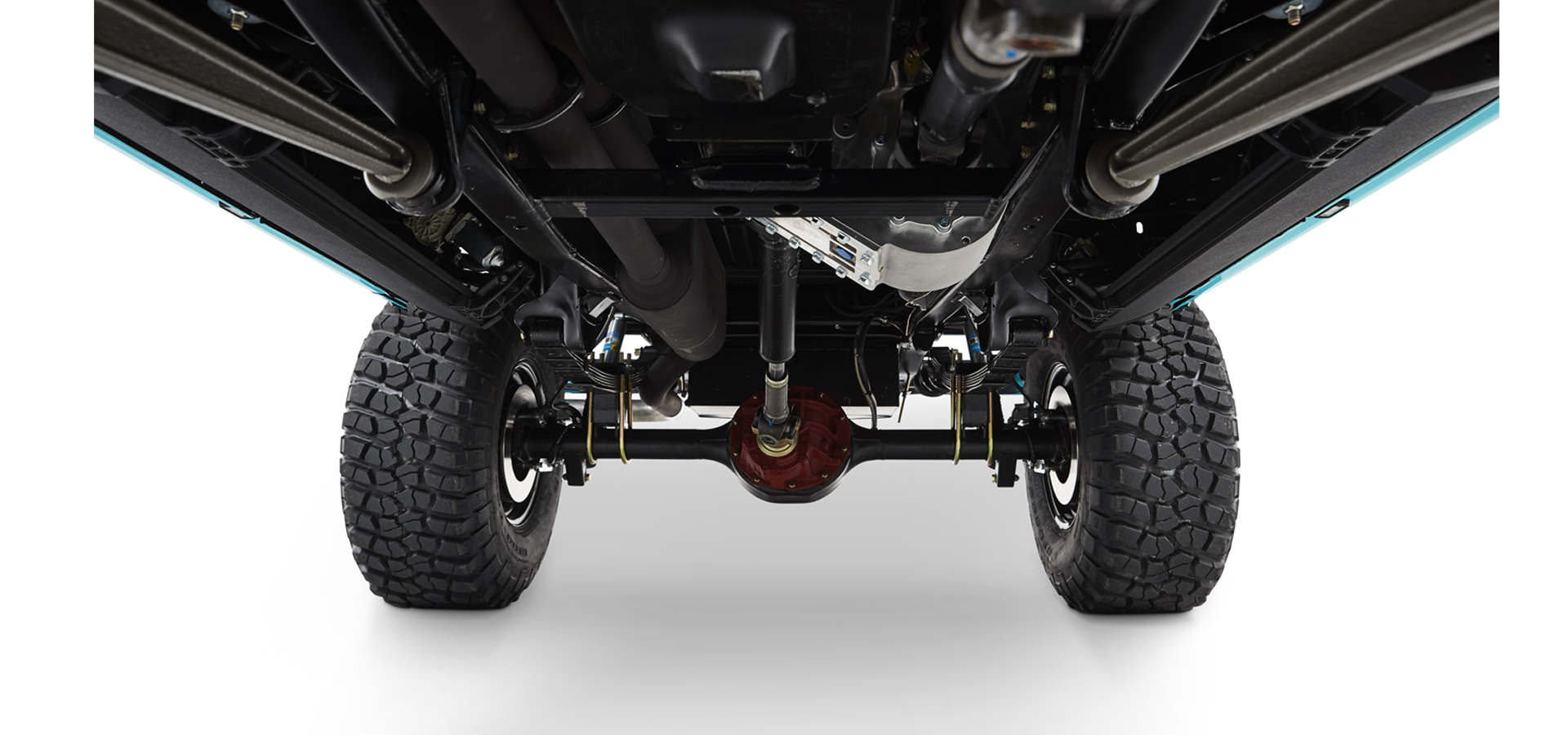 Undercarriage of Classic Ford Bronco showing suspension, drive shaft, axle and large off-road tires
